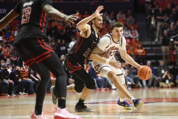 Illinois' Coleman Hawkins, right, dribbles as Rutgers' Caleb McConnell (22) defends during the first half of an NCAA college basketball game, Saturday, Feb. 11, 2023, in Champaign, Ill. (AP Photo/Michael Allio)
