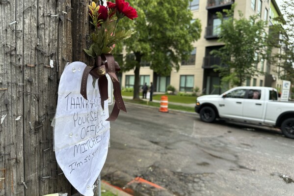 A small tribute marked the scene of a shooting the day prior where at least three people were killed, including a police officer, Friday, May 31, 2024 in Minneapolis. Officer Jamal Mitchell responding to a shooting call was ambushed and killed Thursday when he stopped to provide aid to a man who appeared to be a victim. That man instead wound up shooting the officer, authorities said.(AP Photo/ Mark Vancleave)
