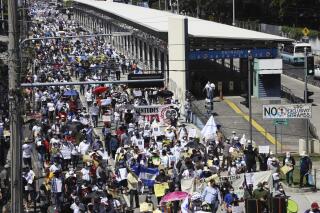 People march during a protest against President Nayib Bukele in San Salvador, El Salvador, Sunday, Oct. 17, 2021. (AP Photo/Salvador Melendez)