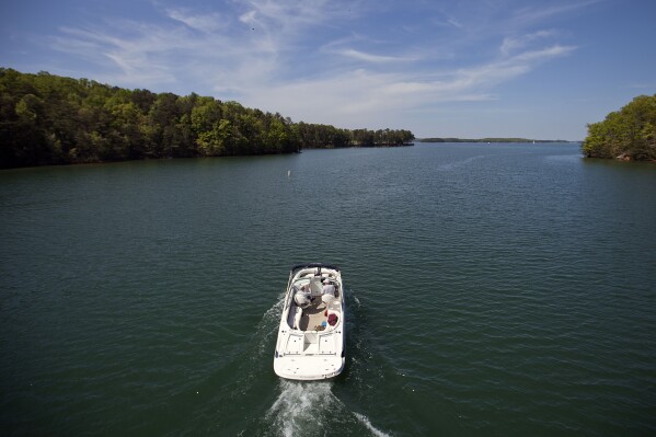 FILE - A boat passes along Lake Lanier, April 23, 2013, in Buford, Ga. Fashion designer Tameka Foster, the ex-wife of R&B singer Usher, is calling to drain Lake Lanier, Georgia's largest lake, where her son was fatally injured 11 years ago. Kile Glover, her 11-year-old son with Bounce TV chairman Ryan Glover, died in July 2012 after a personal watercraft struck the boy as he floated in an inner tube on the lake. (AP Photo/David Goldman, File)