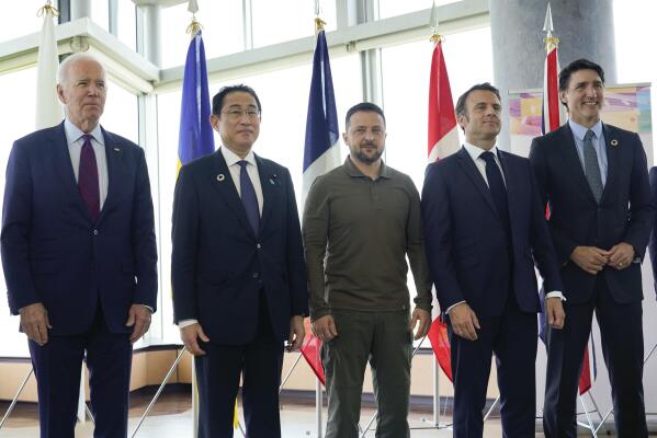President Joe Biden, left, Japanese Prime Minister Fumio Kishida, Canadian Prime Minister Justin Trudeau, right, and French President Emmanuel Macron, second right, stand with Ukrainian President Volodymyr Zelenskyy pose for a photo before a working session on Ukraine during the G7 Summit in Hiroshima, Japan, Sunday, May 21, 2023. (AP Photo/Susan Walsh, POOL)