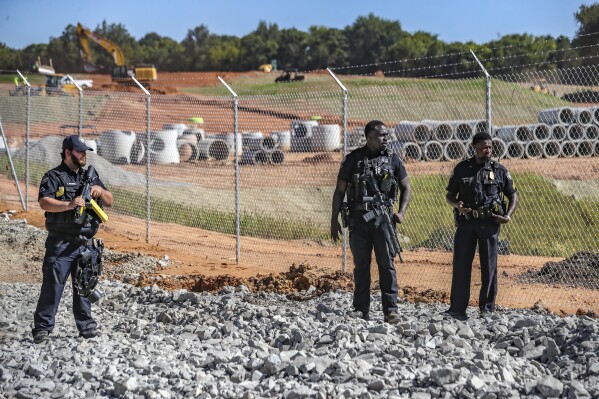 Law enforcement personnel stand at the site of Atlanta's proposed public safety training center, Thursday, Sept. 7, 2023, in DeKalb County, Ga., after several protesters chained themselves to construction equipment in an effort to halt work. (John Spink/Atlanta Journal-Constitution via AP)