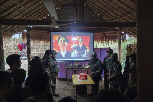 In this photo provided by Thabeikkyin Township People’s Defense Force, the group's members celebrate the 79th birthday of the country’s ousted leader Aung San Suu Kyi with a cake in a hut of the group’s outpost in Thabeikkyin township in Mandalay region, Myanmar, Wednesday, June 19, 2024. (Thabeikkyin Township People’s Defense Force via AP)