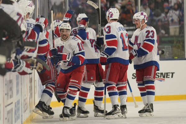 New York Rangers' Vincent Trocheck, left, celebrates with teammates after scoring during the second period of an NHL Stadium Series hockey game against the New York Islanders in East Rutherford, N.J., Sunday, Feb. 18, 2024. (AP Photo/Seth Wenig)