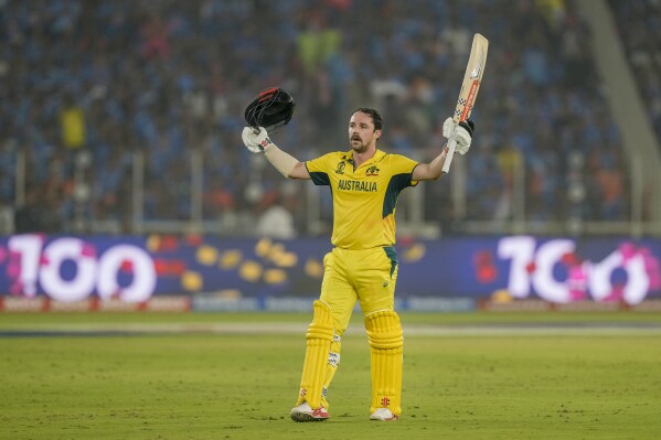Australia's Travis Head raises his bat as he celebrates after scoring a century during the ICC Men's Cricket World Cup final match between Australia and India in Ahmedabad, India, Sunday, Nov.19, 2023. (AP Photo/Mahesh Kumar A.)