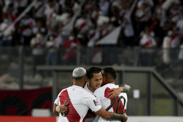 Peru's Gianluca Lapadula, center, celebrates scoring his side's opening goal against Paraguay during a qualifying soccer match for the FIFA World Cup Qatar 2022 in Lima, Peru, Tuesday, March 29, 2022. (AP Photo/Martin Mejia)
