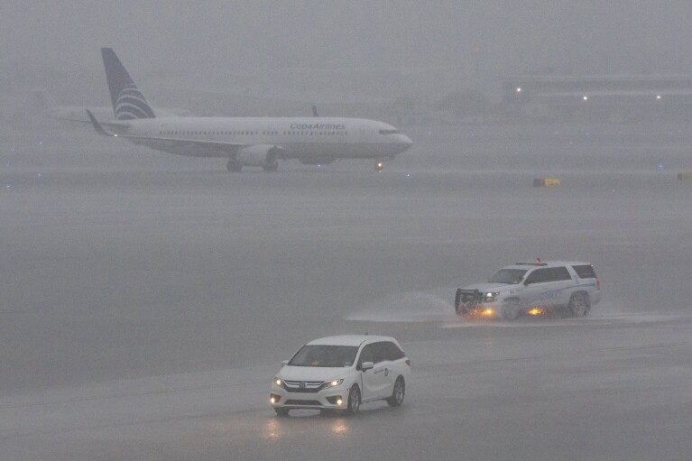 Um avião é visto na pista após fortes chuvas atingirem o Aeroporto Internacional de Fort Lauderdale-Hollywood, quarta-feira, 12 de junho de 2024, em Fort Lauderdale, Flórida.  Muitos voos são cancelados ou atrasados ​​devido ao mau tempo.  (AP via Mathias J. Ochner/Miami Herald)