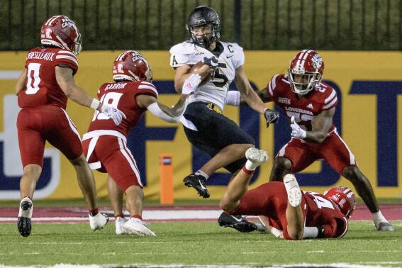Appalachian State wide receiver Thomas Hennigan (5) does a spin move to avoid Louisiana-Lafayette defenders before scoring a touchdown in the second half during the Sun Belt Conference championship NCAA college football game in Lafayette, La., Saturday, Dec. 4, 2021. (AP Photo/Matthew Hinton)