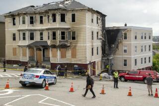 FILE - Officials investigate the scene of a fatal fire, Tuesday, May 17, 2022 in Worcester, Mass.  One of the four people who died in a fire at a Massachusetts apartment building last weekend had filed a defamation lawsuit against right-wing radio host Alex Jones and his InfoWars website in 2018, alleging they falsely identified him as the gunman in a massacre at a Florida high school. A lawyer for 29-year-old Marcel Fontaine confirmed Thursday, May 19, that his client died in Saturday's fire in Worcester.  (Rick Cinclair/Worcester Telegram & Gazette via AP)