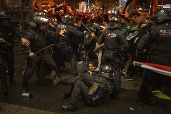 Police officers clash with pro-Palestinian demonstrators trying to enter a train station in Barcelona, Spain, on Nov. 11, 2023. Thousands of protesters had earlier taken part in a march against Israel's response in Gaza to a deadly attack by Hamas on Oct. 7. (AP Photo/Emilio Morenatti)