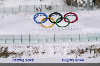 Biathletes skate above the Olympic rings during practice at the 2022 Winter Olympics, Thursday, Feb. 3, 2022, in Zhangjiakou, China. (AP Photo/Kirsty Wigglesworth)