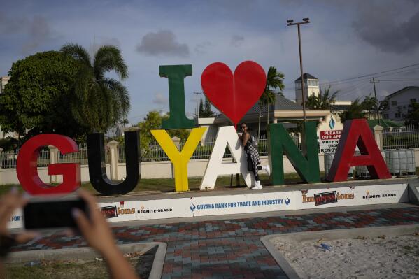 A woman poses for photos in Georgetown, Guyana, Wednesday, April 12, 2023. Guyana, which has one of the world’s highest emigration rates with more than 55% of the population living abroad, now claims one of the world’s largest shares of oil per capita and is expected to have one of the world’s fastest-growing economies, according to a World Bank report. (AP Photo/Matias Delacroix)