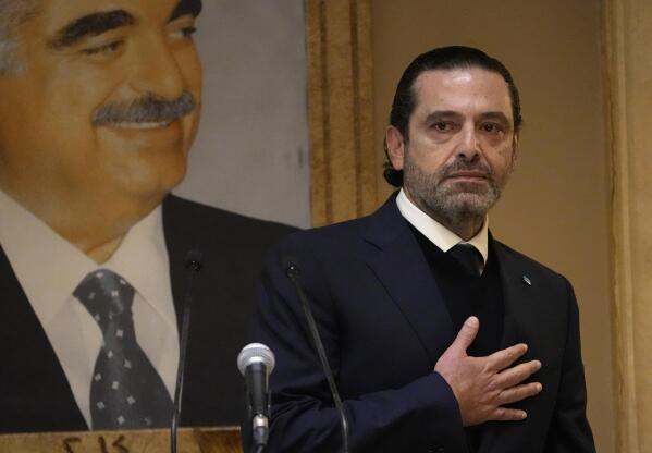 Former Lebanese Prime Minister Saad Hariri, gestures in front of a picture of his late father and former Prime Minister of Lebanon Rafic Hariri, after he gave a speech, at his house in downtown Beirut, Lebanon, Monday, Jan. 24, 2022. Hariri said Monday he is suspending his work in politics and will not run in May's parliamentary elections. (AP Photo/Hussein Malla)