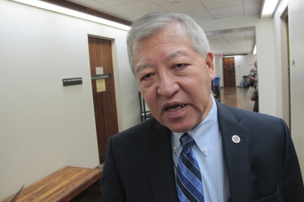 FILE - Honolulu Prosecuting Attorney Keith Kaneshiro talks to The Associated Press in Honolulu, on March 2, 2016. An upcoming bribery trial against Kaneshiro won't be delayed despite an ongoing investigation that one of the defendants in the case allegedly threatened the safety of the judge who had been presiding over the case, which prompted his unexpected recusal last month. (AP Photo/Cathy Bussewitz, File)