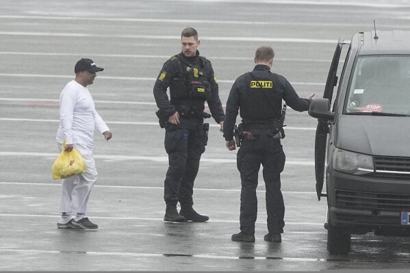 Danish police officers accompany financier Sanjay Shah as he arrives at Kastrup Airport, in Copenhagen, Wednesday, Dec. 6, 2023. Shah, a Dubai-based British hedge fund trader sought by Danish authorities for allegedly orchestrating a $1.7 billion tax fraud, considered one of the largest in the Scandinavian country, has been extradited from the United Arab Emirates, officials said Wednesday. (Mads Claus Rasmussen/Ritzau Scanpix via AP)