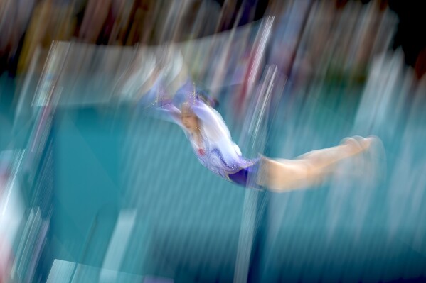 Qiu Qiyuan, of China, warms up during the women's artistic gymnastics individual uneven bars finals at Bercy Arena at the 2024 Summer Olympics, Sunday, Aug. 4, 2024, in Paris, France. (AP Photo/Abbie Parr)