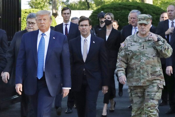 FILE - In this June 1, 2020 file photo, President Donald Trump departs the White House to visit outside St. John's Church, in Washington. Walking behind Trump from left are, Attorney General William Barr, Secretary of Defense Mark Esper and Gen. Mark Milley, chairman of the Joint Chiefs of Staff. Experts in constitutional law and the military say the Insurrection Act gives presidents tremendous power with few restraints. Recent statements by former President Donald Trump raise questions about how he might use it if he wins another term. (AP Photo/Patrick Semansky, File)