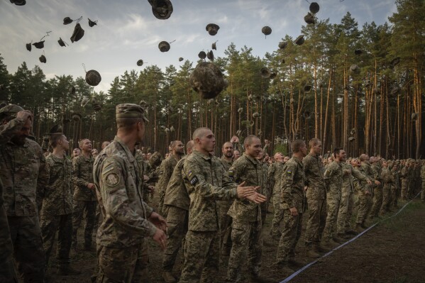 Newly recruited soldiers shout slogans as they celebrate the end of their training at a military base close to Kyiv, Ukraine, Monday, Sept. 25, 2023. (APPhoto/Efrem Lukatsky)