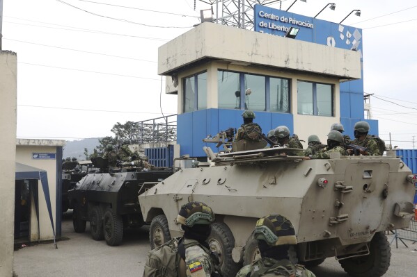 Armored vehicles enter the Deprivation of Liberty Center of the Zone 8 in Guayaquil, Ecuador, Saturday, Aug. 12, 2023. Military personnel entered the facility to transfer Adolfo Macias, alias “Fito” considered the head of Los Choneros, an organized crime group. Slain presidential candidate Fernando Villavicencio had accused Macias of having threatened him. (AP Photo/Cesar Munoz)