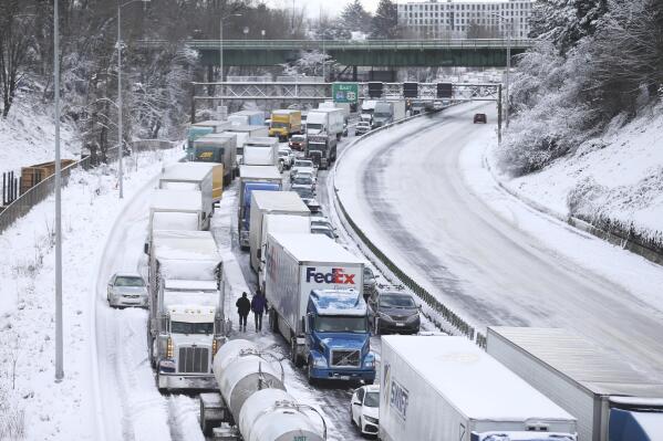 The backup of cars and trucks stuck on Interstate 84 is seen from the Blumenauer Bicycle and Pedestrian Bridge in Northeast Portland, Ore., Thursday, Feb. 23, 2023. Nearly a foot of snow fell in Portland on Wednesday. (Dave Killen /The Oregonian via AP)