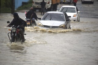 FILE - Motorists wade through a flooded road in Mombasa town after a heavy downpour on Friday Nov.3, 2023. Aid agencies say heavy rains and flash flooding have killed at least 30 people and displaced tens of thousands in Kenya and Somalia. (AP Photo/Gideon Maundu, File)