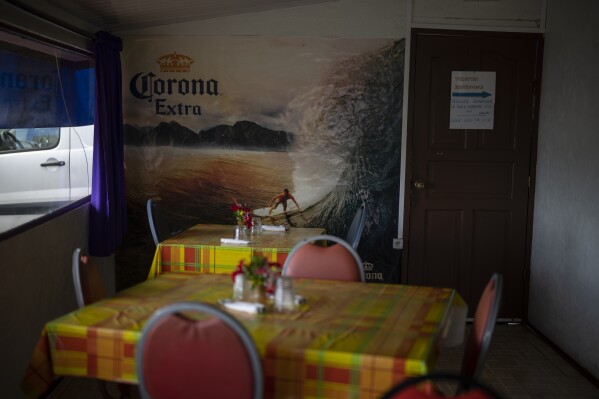 On Thursday, January 11, 2024, an advertisement featuring Te Aup'o waves covers the walls of the only snack bar in the village of T'aup'o on the island of Tahiti, French Polynesia.  (AP Photo/Daniel Cole)