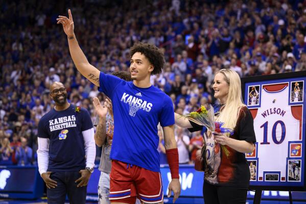 FILE - Kansas forward Jalen Wilson acknowledges the cheers of the crowd, with his family, during Senior Night before the first half of an NCAA college basketball game against Texas Tech in Lawrence, Kan., Tuesday, Feb. 28, 2023. Jalen Wilson was named The Associated Press Big 12 player of the year in voting released Tuesday, March 7, 2023. (AP Photo/Reed Hoffmann, File)