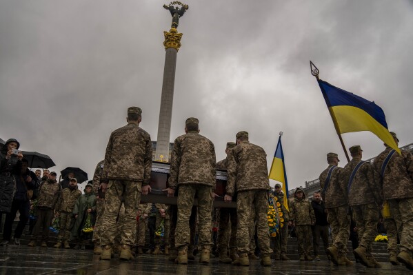 Honour guards carry the coffin of Ukrainian army paramedic Nazarii Lavrovskyi, 31, killed in the war, during his funeral ceremony at Independence square in Kyiv, Wednesday, April 24, 2024. Lavrovskyi, who served in the 244th battalion of the 112th Separate Territorial Defense Brigade, was killed April 18 while helping to evacuate wounded troops from the frontline in the Kharkiv area of eastern Ukraine. (AP Photo/Francisco Seco)