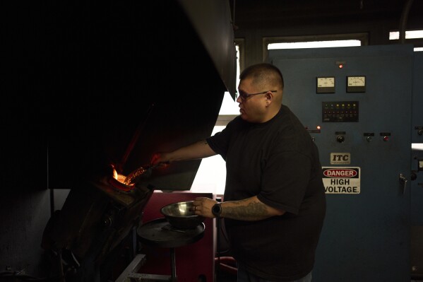 Melter Alberto Hernandez loads gold into a crucible at A&M Precious Metals in the St. Vincent Jewelry Center in the Jewelry District of Los Angeles, Friday, May 2, 2025. (AP Photo/Jae C. Hong)