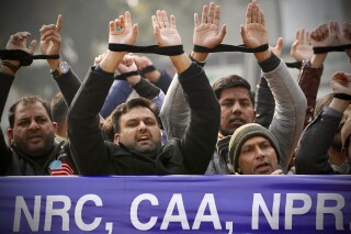 FILE- Indians raise their tied hands and shout slogans during a protest against the Citizenship Amendment Act in New Delhi, India, Dec. 27, 2019. Prime Minister Narendra Modi's government on Monday announced rules to implement a 2019 citizenship law that critics say is discriminatory against Muslims, weeks before the Hindu nationalist leader will seek a third term in office. (AP Photo/Manish Swarup, File)
