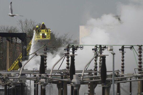 Firefighters extinguish the fire at the North Hyde electrical substation, which caught fire Thursday night and lead to a closure of Heathrow Airport in London, Friday, March 21, 2025. (AP Photo/Kirsty Wigglesworth)