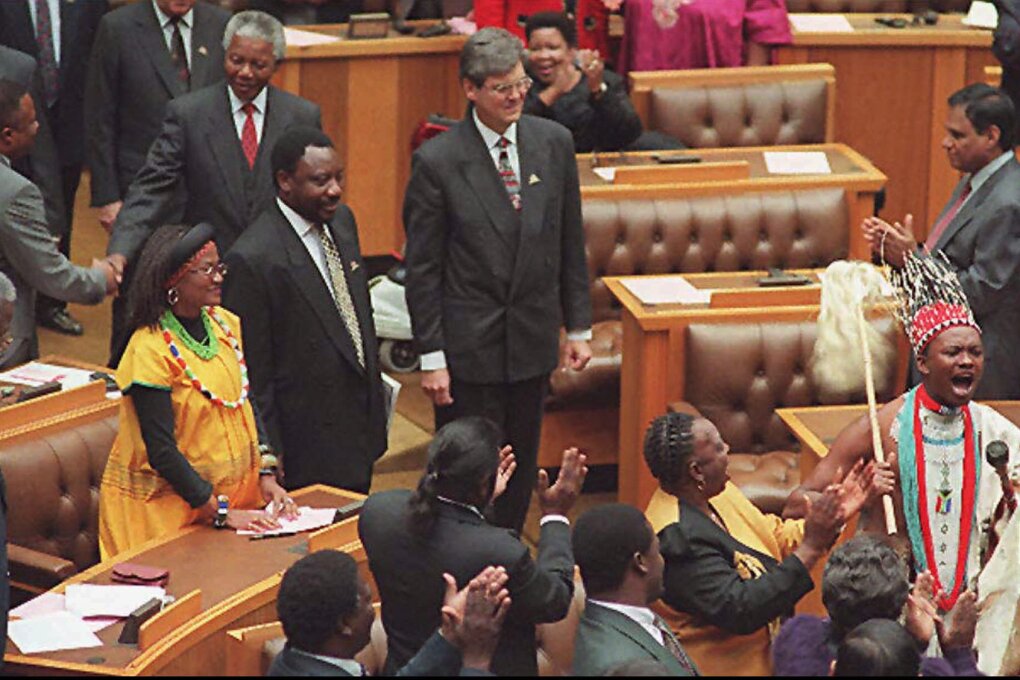 A praise-singer leads the way as Cyril Ramaphosa, center left, head of the Constitutional Assembly, his deputy Leon Wessels, center, right, and President Nelson Mandela, behind,  arrive at the Constitutional Assembly in Cape Town Wednesday May 8, 1996. South Africa adopted a new constitution that guarantees equal rights and majority rule and completes the transformation from the injustice of apartheid to a liberal democracy.(AP Photo/Anna Zieminski/POOL)