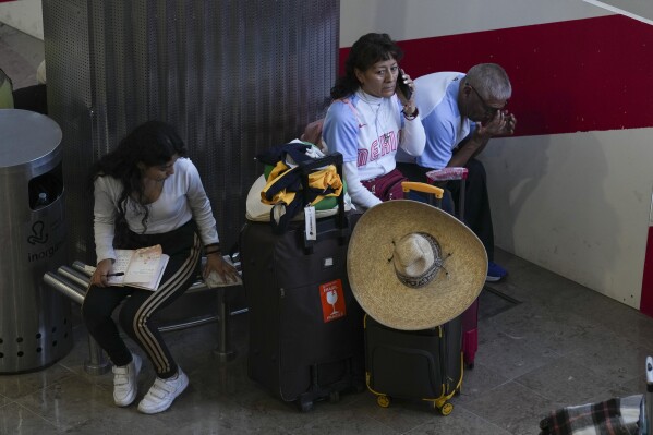 Passengers wait at Benito Juárez International Airport in Mexico City, Friday, July 19, 2024. Some flights were canceled and others were delayed amid a global technology outage. (AP Photo/Marco Ugarte)