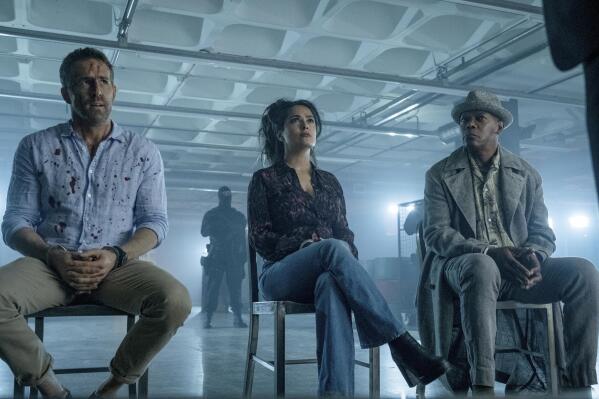 This image released by Lionsgate shows Ryan Reynolds, from left, Salma Hayek and Samuel L. Jackson in a scene from "The Hitman's Wife's Bodyguard." (David Appleby/Lionsgate via AP)