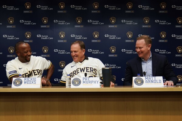 Pat Murphy shakes hands with associate manager Rickie Weeks and general manager Matt Arnold at a news conference where he was named Milwaukee Brewers baseball team manager Thursday, Nov. 16, 2023, in Milwaukee. (AP Photo/Morry Gash)