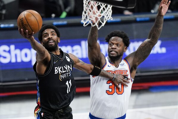 Brooklyn Nets' Kyrie Irving (11) drives past New York Knicks' Julius Randle (30) during the first half of an NBA basketball game Monday, April 5, 2021, in New York. (AP Photo/Frank Franklin II)