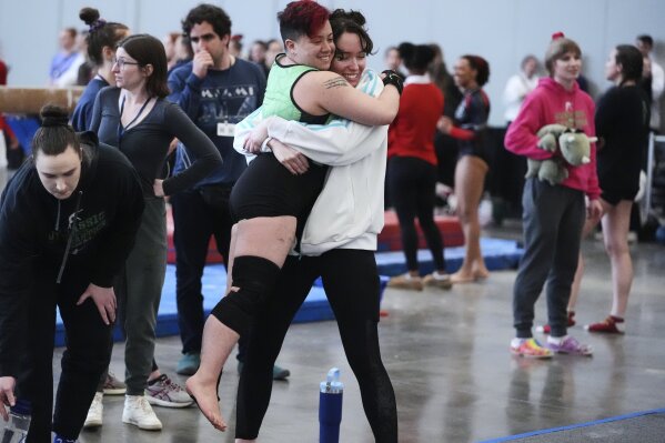 Raiden Hung of Jurassic Gymnastics from Boston, center left, celebrates with teammate Fay Malay after competing in the floor exercise at the 2025 NAIGC national competition in Pittsburgh, Friday, April 4, 2025. (AP Photo/Gene J. Puskar)