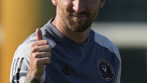 Lionel Messi gives a thumbs up toward journalists on the sideline as he participates in a training session for the Inter Miami MLS soccer team Tuesday, July 18, 2023, in Fort Lauderdale, Fla. (AP Photo/Rebecca Blackwell)