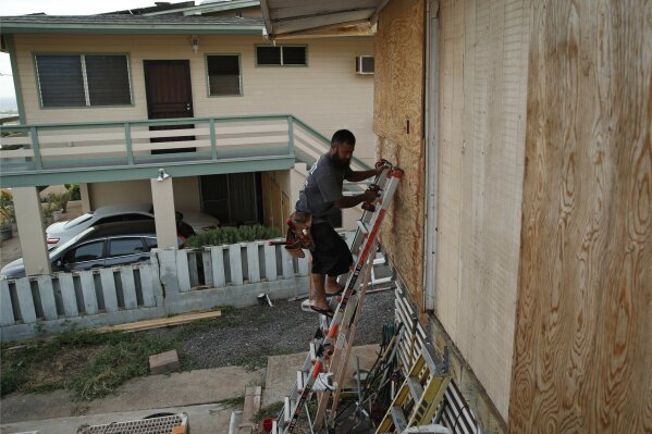 
              Kaipo Popa secures plywood to protect windows on a home in preparation for Hurricane Lane, Wednesday, Aug. 22, 2018, in Kapolei, Hawaii. As emergency shelters opened, rain began to pour and cellphone alerts went out, the approaching hurricane started to feel real for Hawaii residents.(AP Photo/John Locher)
            