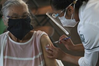 An elderly woman gets her shot of the Pfizer vaccine for COVID-19 in Mexico City, Monday, March 8, 2021. (AP Photo/Marco Ugarte)