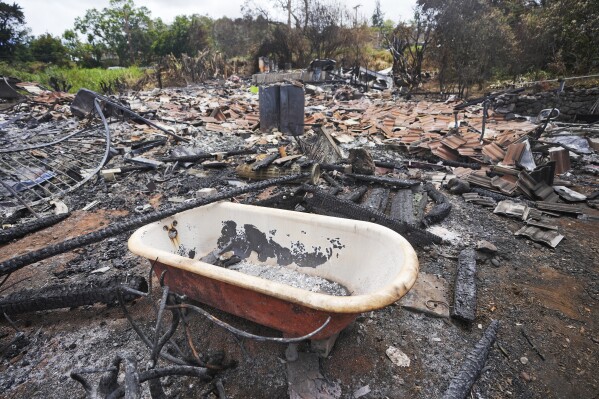 Un char se trouve au milieu d'une maison détruite par des incendies de forêt à Kula, Hawaï, le lundi 14 août 2023.  Un incendie de forêt a ravagé Lahaina le même jour, et un a ravagé Kula.  (AP Photo/Rick Bomer)