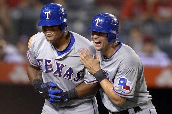 FILE - Texas Rangers' Adrian Beltre, left, celebrates with Michael Young after hitting a two-run home run during then ninth inning of their baseball game against the Los Angeles Angels, Thursday, Sept. 20, 2012, in Anaheim, Calif. The former Rangers teammates will be managers for the All-Star Futures Game on July 13 at Globe Life Field in Arlington, Texas Beltré will lead the AL team and Young the NL team, Major League Baseball said Tuesday, June 4, 2024. (AP Photo/Mark J. Terrill, File)