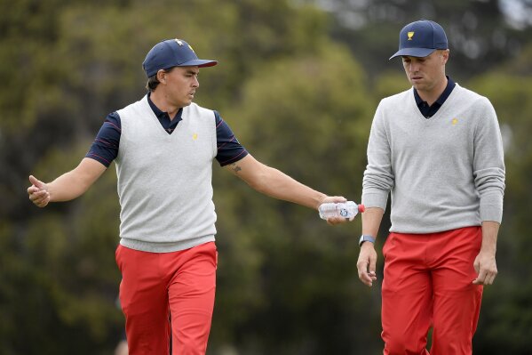 U.S. team player Rickie Fowler, left, and playing partner Justin Thomas talk while walking on the 6th fairway in their foursome match during the President's Cup golf tournament at Royal Melbourne Golf Club in Melbourne, Saturday, Dec. 14, 2019. (AP Photo/Andy Brownbill)