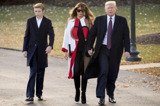 
              FILE- In this Nov. 20, 2018, file photo President Donald Trump accompanied by first lady Melania Trump, and their son Barron, left, walks towards Marine One on the South Lawn of the White House in Washington. Trump says he wouldn't steer son Barron toward football, saying it's "a dangerous sport," but also wouldn't stand in the way if the soccer-playing 12-year-old wanted to put on pads. The NFL fan tells CBS' "Face the Nation" in an interview taped before the Super Bowl that football is "really tough." (AP Photo/Andrew Harnik, File)
            