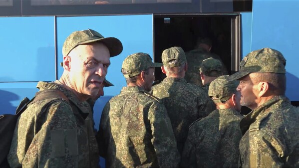 In this photo taken from video released by Russian Defense Ministry Press Service on Saturday, May 24, 2025, Russian servicemen board a bus upon arrival to Chkalovsky airport, outside Moscow, Russia, after returning from captivity by a POWs exchange between Russia and Ukraine. (Russian Defense Ministry Press Service photo via AP)