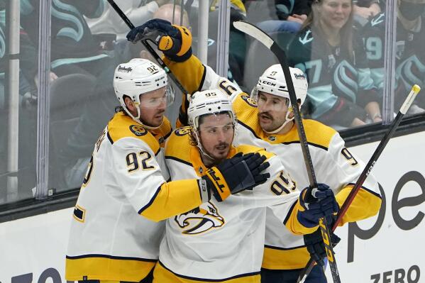 Nashville Predators' Matt Duchene (95) is congratulated after scoring against the Seattle Kraken by Ryan Johansen (92) and Filip Forsberg in the third period of an NHL hockey game Tuesday, Jan. 25, 2022, in Seattle. (AP Photo/Elaine Thompson)
