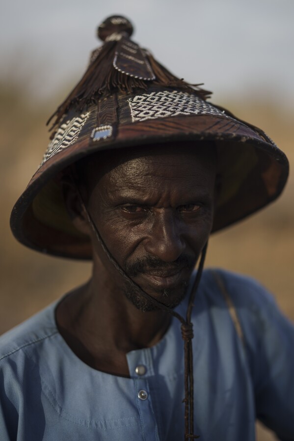 Amadou Altine Ndiaye stands for a portrait in the village of Yawara Dieri, in the Matam region of Senegal, Saturday, April 15, 2023. The 48 year-old herder, who had cattle and sheep present at his birth, says that he was born into pastoralism, and since then he has known only that. For Ndiaye, who began tending to his family's flock when he was just 8 years old, his profession is also an inherited tradition. "It's a source of pride. ... We Fulanis would be lost if we had to change our method of pastoralism because those who haven't studied couldn't adapt to modern methods," he says. "The best thing is to continue with our know-how." (AP Photo/Leo Correa)