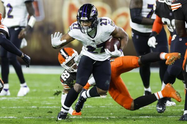 Baltimore Ravens running back J.K. Dobbins (27) carries the ball past Cleveland Browns safety Grant Delpit (22) during the first half of an NFL football game, Saturday, Dec. 17, 2022, in Cleveland. (AP Photo/Ron Schwane)