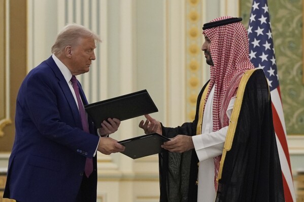 President Donald Trump and Saudi Crown Prince Mohammed bin Salman exchange documents during a signing ceremony at the Royal Palace, Tuesday, May 13, 2025. (AP Photo/Alex Brandon)