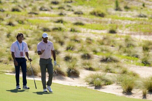 Tiger Woods walks with his son Charlie, on the sixth hole during a practice round for the U.S. Open golf tournament Tuesday, June 11, 2024, in Pinehurst, N.C. (AP Photo/George Walker IV)